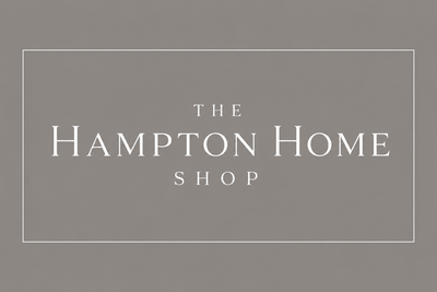 Logo of The Hampton Home Shop on a gray background